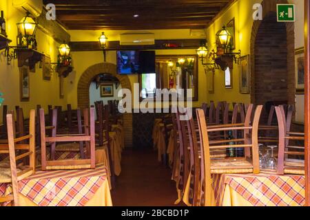 Sedie e tavoli accatastati in un ristorante italiano tradizionale chiuso, Roma, Italia Foto Stock