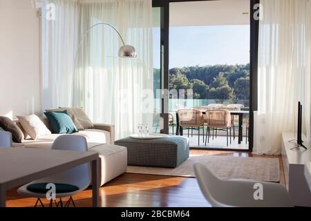 Soggiorno moderno e luminoso con grande balcone e vista sulla natura. Foto Stock