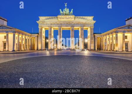 Il Brandenburger Tor illuminato a Berlino all'alba senza persone Foto Stock