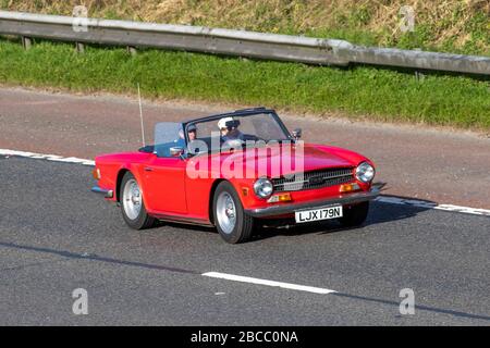 1975 70s anni Settanta, 1970s rosso Triumph TR6; veicoli in movimento per il traffico veicolare, veicoli in auto su strade britanniche, motori, automobili sull'autostrada M6 Foto Stock