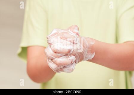 Bambino piccolo lavando le mani con sapone, primo piano. Importanza del concetto di igiene personale Foto Stock