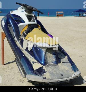 Dirty Old Jet Ski parcheggiato sulla spiaggia della stagione delle feste. Old Jet Skis sulla spiaggia su Trailer in legno. Blue and White Jet Ski - Dubai Emirati Arabi Uniti Gennaio 2020 Foto Stock