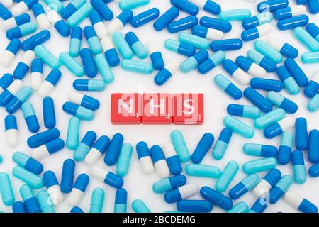 Piastrelle per lettere NHS e pillole blu assortite. Per il 75 ° compleanno NHS, eroi NHS, prescrizioni NHS, UK National Health Service, medicina nel Regno Unito Foto Stock