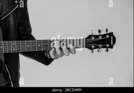 Varsavia , Polonia/ 15 marzo: Foto in bianco e nero di un maschio che suona sulla chitarra moderna Hohner. Uomo con le dita che toccano la chitarra HOHNER Strings enjoyi Foto Stock