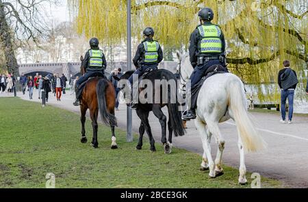 Amburgo, Germania. 04th Apr, 2020. Gli agenti di polizia montati cavalcano pattuglie in un parco sull'Alster esterno per garantire che il divieto di contatto sia rispettato per contenere il coronavirus. E' vietato sedersi fuori su panchine e prati. Credito: Markus Scholz/dpa/Alamy Live News Foto Stock