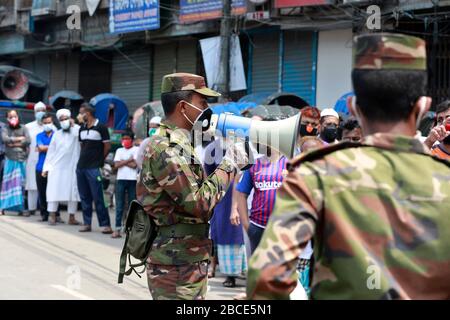 Dhaka, Bangladesh - 04 aprile 2020: Gli esecutori della legge esortano le persone a rimanere a casa nel quartiere Nayabazar della capitale sabato in mezzo ai coronavi Foto Stock