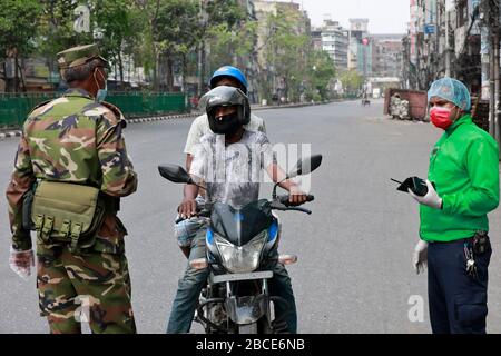 Dhaka, Bangladesh - 04 aprile 2020: Gli esecutori della legge esortano le persone a rimanere a casa nel quartiere Nayabazar della capitale sabato in mezzo ai coronavi Foto Stock