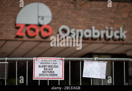 04 aprile 2020, bassa Sassonia, Osnabrück: 'ue alla situazione attuale lo zoo sarà chiuso fino a nuovo avviso' è scritto su un segno dello Zoo di Osnabrück. Accanto ad essa è una nota dipinta a mano con la frase 'ci manca voi' e i nomi di vari animali dello zoo. I visitatori non si trovano sulla base dell'attrazione altrimenti ben frequentata. A causa della crisi del Corona, i giardini zoologici sono attualmente chiusi. Foto: Friso Gentsch/dpa Foto Stock