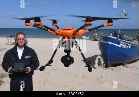 04 aprile 2020, Mecklenburg-Vorpommern, Baabe: Dieter Teetz, dipendente dell'Ordnungsamt Mönchgut-Granitz, avvia un salvataggio (drone) sulla spiaggia di Baabe sull'isola di Rügen. Sulle spiagge dell'ufficio Mönchgut-Granitz di Rügen tra Göhren, Baabe e Sellin, un drone, un cosiddetto soccorecopter, è utilizzato dalla vigili del fuoco per controllare le restrizioni nella vita pubblica. Il drone può anche rilevare feste barbecue con la termocamera. A causa delle severe restrizioni nella vita pubblica, l'inizio tradizionale della stagione nel Mar Baltico a Pasqua sarà cancellato questo voi Foto Stock