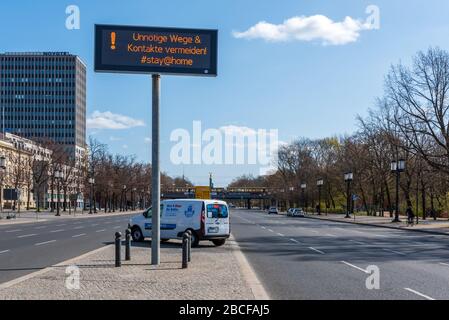 Cartello che dice alle persone di rimanere a casa ed evitare contatti inutili sulla Strasse des 17. Juni nel centro di Berlino durante il blocco Covid, aprile 2020 Foto Stock