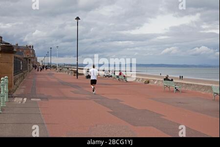 Portobello Beach and Promenade, Edimburgo, Scozia, Regno Unito. 4 aprile 2020. A metà pomeriggio, nuvoloso 10 gradi con spiaggia tranquilla ma a volte molto trafficata Promenade, causato da ciclisti accatastati e tessitura attraverso i pedoni. Inoltre, la prima volta ci è stata una presenza della polizia in questo momento della giornata nel corso delle due settimane durante Coronavirus Lockdown, forse nelle aspettative del tempo migliore previsto domani quando le temperature più calde sono previste. Foto Stock