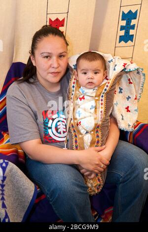 Madre indiana con il bambino al North American Plaims Native Indian in abito tradizionale a Pow Wow nel villaggio indiano al Calgary Stampede Foto Stock