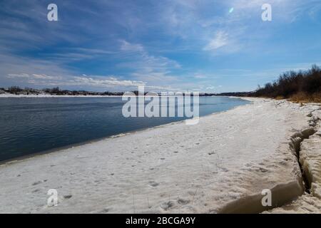 Splendide viste sul fiume South Saskatchewan parzialmente ghiacciato nella stagione primaverile Foto Stock