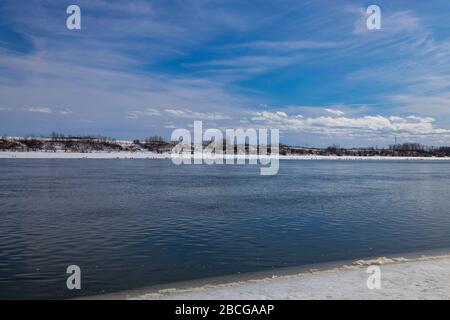 Splendide viste sul fiume South Saskatchewan parzialmente ghiacciato nella stagione primaverile Foto Stock