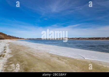 Splendide viste sul fiume South Saskatchewan parzialmente ghiacciato nella stagione primaverile Foto Stock