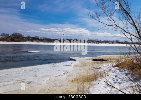 Splendide viste sul fiume South Saskatchewan parzialmente ghiacciato nella stagione primaverile Foto Stock