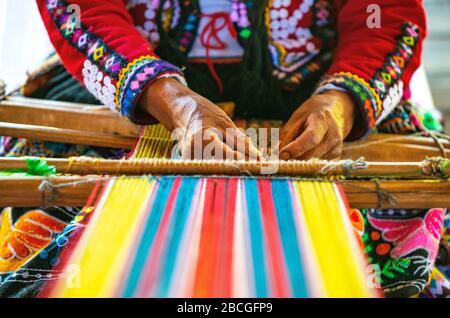 Donna quechua indigena peruviana che tessere un tessuto con le tecniche tradizionali in Cusco, Perù. Foto Stock