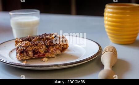 casa fatto sano cereale bars.in cucina con bicchiere di latte miele pentola, & drizzler, Foto Stock