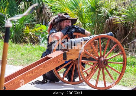 Un attore pirata si appoggia su un cannone al Florida Renaissance Festival - Quiet Waters Park, Deerfield Beach, Florida, USA Foto Stock