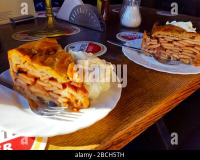 Due fette di torta di mele con panna montata su un tavolo di legno in un pub olandese ad amsterdam Foto Stock