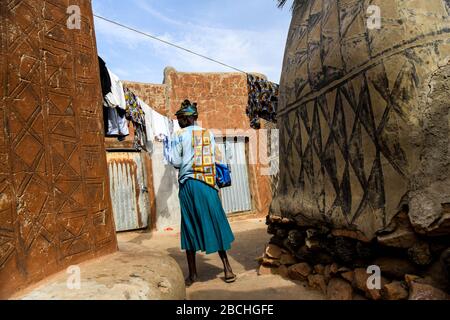 Africa, Burkina Faso, regione di Pô, Tiebele. Vista panoramica della corte reale di Tiebele. Una donna cammina per appendere un po' di lavanderia Foto Stock
