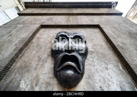 Maschera teatrale in bronzo rilievo con triste volto su High Street wellhead sul Royal Mile a Edimburgo, Scozia, Regno Unito, per indicare la tristezza della cancellazione del festival Edinburgh Fringe 2020. Foto Stock