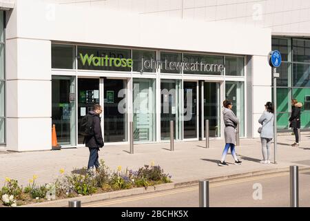 Gli acquirenti che fanno la fila e mantengono una distanza sociale di 2 m al di fuori di Waitrose a Basingstoke durante la pandemia Coronavirus Covid-19, 4 aprile 2020 Foto Stock