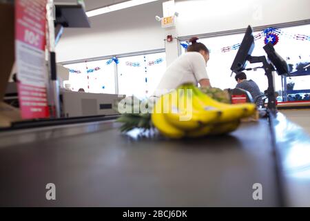 Il nastro trasportatore del negozio di alimentari sposta le banane al banco di cassa. Foto Stock