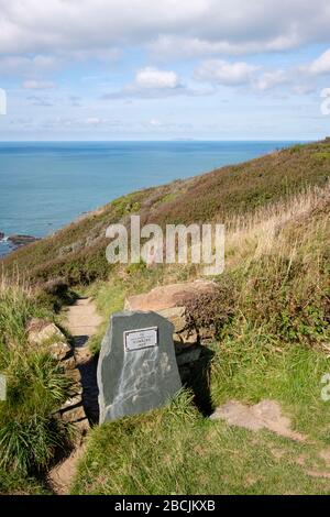 Il cartello in pietra del National Trust è chiaramente visibile dal South West Coast Path e segna il sentiero verso il basso fino al rifugio di Hawker Foto Stock