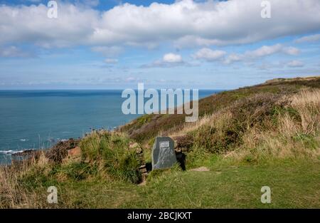 Il cartello in pietra del National Trust è chiaramente visibile dal South West Coast Path e segna il sentiero verso il basso fino al rifugio di Hawker Foto Stock