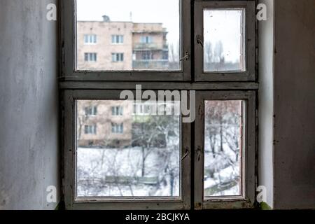 Corridoio interno in vecchio edificio di appartamenti sovietici a Rivne, Ucraina in inverno con nessuno in run-down chiuso finestra interno del piano Foto Stock