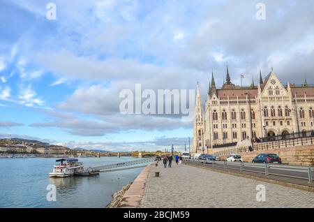 Budapest, Ungheria - 6 novembre 2019: Edificio del Parlamento ungherese Orszaghaz. La sede dell'Assemblea Nazionale. Edificio con la strada adiacente, la passeggiata e il fiume Danubio su un quadro orizzontale. Foto Stock