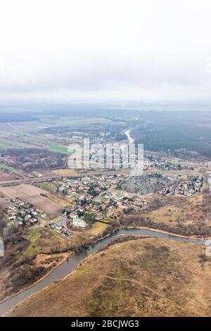 Nowy Dwor, Polonia sopra alto angolo verticale vista dalla finestra vicino aeroporto con rurale inverno marrone paesaggio campagna vicino a Varsavia e fiume in fattoria Foto Stock