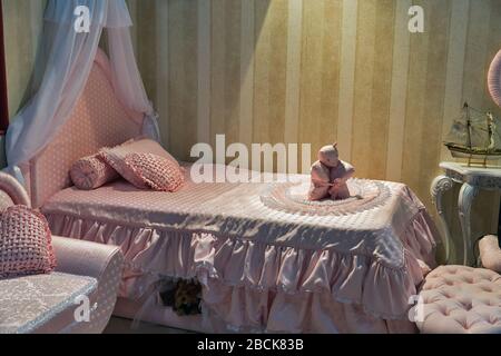 Camera da letto vuota per bambina moderna con biancheria da letto a motivi eleganti e cuscini Foto Stock