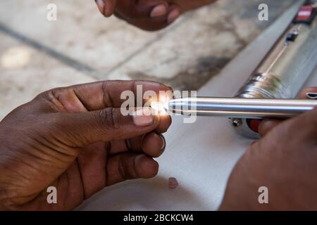 Africa, Madagascar, regione di Ilhorombe, Ilakaka. Uno dei più grandi giacimenti di zaffiro alluvionale conosciuti al mondo scoperto nel 1998. Uomini molatura e lucidatura Foto Stock