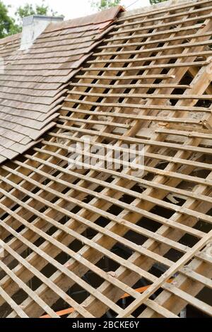 La sostituzione delle vecchie piastrelle rivela il mancato allargamento del tetto con travi rotte su una casa nel Regno Unito Foto Stock