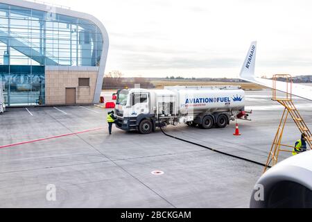 Lviv, Ucraina - 22 gennaio 2020: Esterno dell'edificio aeroportuale a basso costo a Lvov con i lavoratori che alimentano l'aereo Ryanair nella città Ucraina Foto Stock