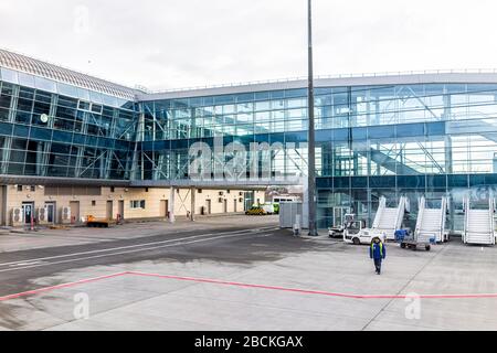 Lviv, Ucraina - 22 Gennaio 2020: Esterno di un piccolo e moderno edificio aeroportuale a basso costo a Lvov con persone che camminano con trasporto concourse in Foto Stock