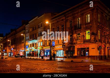 Lviv, Ucraina - 22 gennaio 2020: Storica città Ucraina Lvov nella città vecchia Svobody Avenue con negozi di notte con luci di strada illuminate Foto Stock