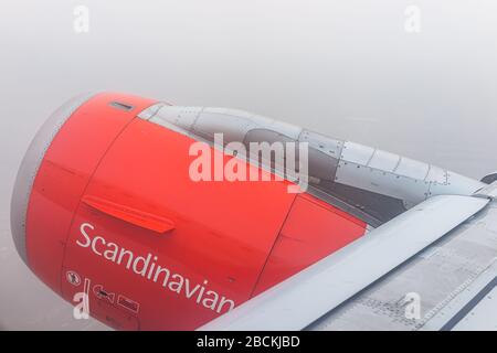 Varsavia, Polonia - 23 gennaio 2020: Motore aereo arancione in cielo con vista dalla finestra ad alto angolo durante nebbia nubi nebbia nebbia e segno per Scandinavian Air Foto Stock