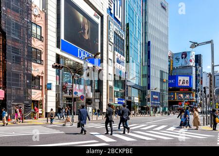 Tokyo, Giappone - 2 aprile 2019: Passeggiata a Shinjuku con salaryman business molte persone che attraversano la strada di mattina ora di punta per raggiungere la strada vicino a Constru Foto Stock