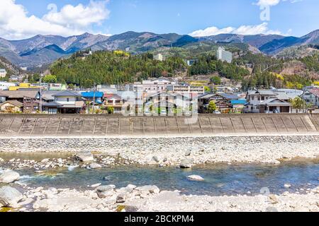 Gero Onsen, Giappone - 8 aprile 2019: Città del villaggio paesaggio urbano nella prefettura di Gifu con il fiume Hida e vista della montagna in primavera durante il giorno Foto Stock