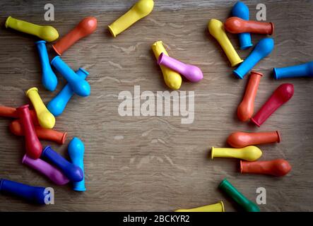 set di palloncini per bambini in vari colori, sgonfi su una base in legno Foto Stock