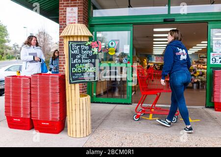 Reston, USA - 1 aprile 2020: Trader Joe's negozio di alimentari segno per la distanza sociale cliente distanziando dal negozio di ingresso con le persone in linea, dipendente WO Foto Stock