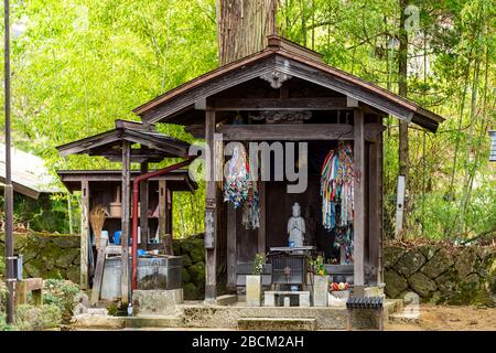 Takayama, Giappone - 9 aprile 2019: Piccolo altare buddista con statua in pietra di Buddha a Tounin o tempio del santuario di Tounin-ji al percorso a piedi di Higashiyama Foto Stock