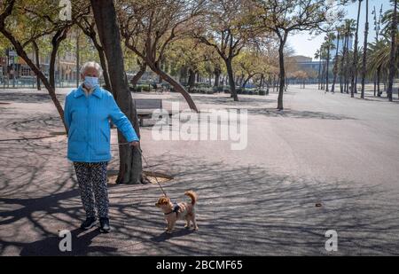 Un uomo che indossa una maschera come misura preventiva, camminando il suo animale domestico durante il contagio di Covid-19.Barcelona sta affrontando il suo ventunesimo giorno di confinamento domestico. Dopo l'annuncio del presidente del governo spagnolo, Pedro Sánchez, di estendere il confinamento delle case, i cittadini spagnoli saranno confinati fino al 25 aprile. Foto Stock