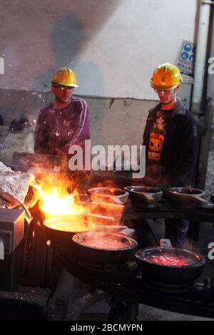 ISTANBUL, TURCHIA - 10 NOVEMBRE: I lavoratori turchi lavorano duramente in una fonderia il 10 novembre 2013 a Istanbul, Turchia. Metallo fuso versato dalla siviera. Foto Stock