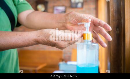 Gel igienizzante per mani per donne anziane per l'igiene delle mani per la pulizia delle mani prevenzione della diffusione del virus corona. Donna che usa l'alcool per lavare le mani. Foto Stock
