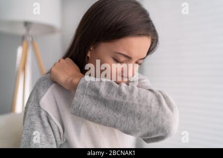 COVID-19 coprire la tosse Coronavirus ridurre il rischio di diffondere l'infezione coprendo naso e bocca quando tosse e starnuti con tessuto o gomito flesso. Donna asiatica tosse nella prevenzione del braccio. Foto Stock