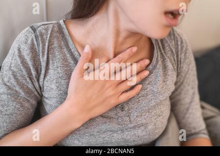 COVID-19 mancanza di polmonite da respiro donna con sintomi del virus Corona come febbre, dolori corporei difficoltà respiratorie. Foto Stock